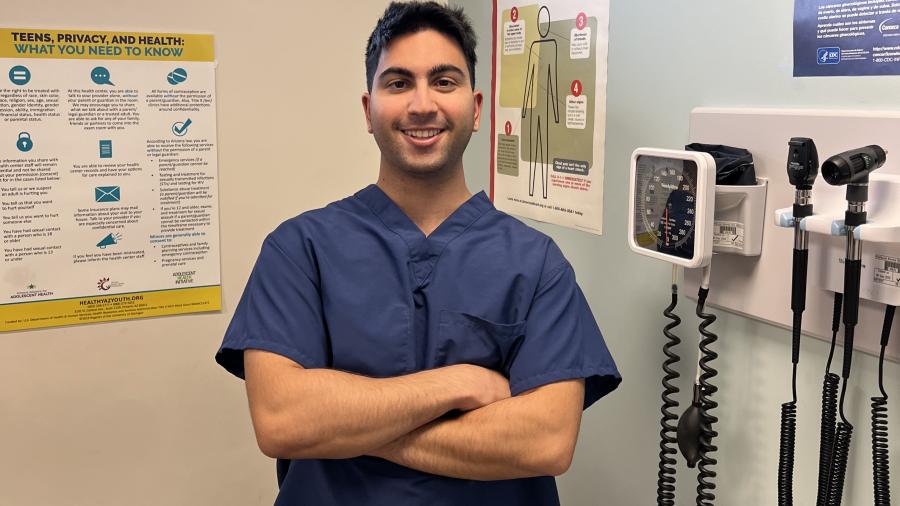 photo of bryan yavari in navy blue scrubs posing in a medical clinic