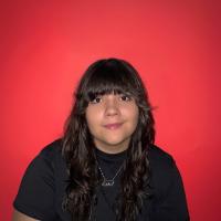 A headshot of a woman against a red background.